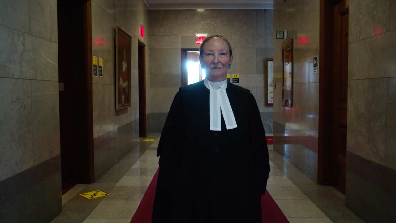 a woman in a judicial robe standing in a hallway